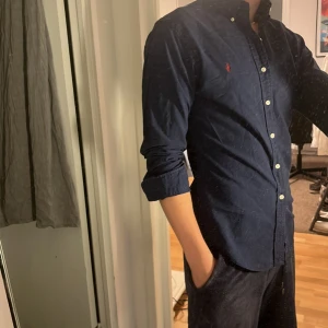 Ralph Lauren Skjorta - Tja säljer en Ralph lauren skjorta i färgen marinblå och i storlek S men passar m också. Nypris 1595 KR mitt pris 349 KR. Inga defekter som hål eller fläckar. Skriv vid frågor eller funderingar.