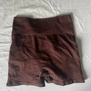 Bruna seamless träningstights shorts S - Mörkbruna seamless shorts med hög midja och tight passform. Tillverkade i stretchigt material med 92% polyamid och 8% elastan. 