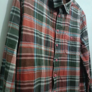 Rutig skjorta Dressmann 2XL - Rutig skjorta från Dressmann i storlek 2XL. Skjortan har gröna, röda och beige toner med rosa knappar och en bröstficka. Tillverkad i mjuk bomull och har klassisk krage samt långa ärmar. Perfekt för dig som gillar avslappnad stil.