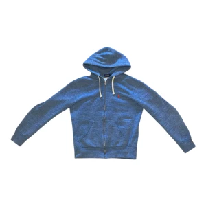Blå zip hoodie från Polo Ralph Lauren XS - Snygg blå zip hoodie från Polo Ralph Lauren i storlek XS. Tröjan har huva med vita snören, dragkedja framtill och fickor. Det klassiska röda Polo-logot broderat på bröstet ger en clean look. Perfekt för chill dagar och enkel att matcha med jeans.