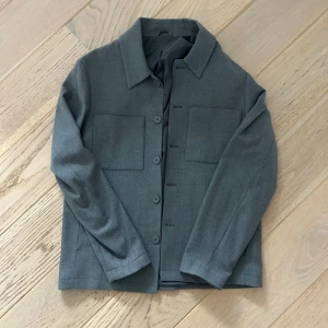 Grå overshirt från Les Deux - Snygg grå overshirt från Les Deux med klassisk krage och raka linjer. Mitt pris - 399 kr. Mycket bra skick, nästintill ny