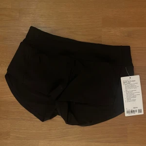Svarta träningsshorts från Lululemon - Speed Up LR Short 2.5'' från Lululemon i svart, med låg midja och tre fickor i midjebandet. Supersnygga men tyvärr för små på mig!! Aldrig använda, med lapp fortfarande på. Nypris 650 kr (68 dollar)
