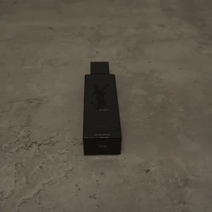 YSL svart parfymflaska - Stilren svart parfymflaska från YSL, perfekt för dig som gillar exklusiva accessoarer. Eau de Parfum. Snygg design som sticker ut och passar i väskan eller på hyllan. En 60ml Ysl parfym som är perfekt nu till vintern eller till en perfekt present  som även kommer med prov  parfym. 