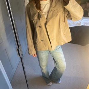 Beige rock från Object, storlek 44 - Säljer en beige rock från Object i storlek 44 men sitter snyggt på mig som brukar ha 38. Jackan har en loose passform, bred krage och dubbla knappar framtill. Tillverkad i bomullsmaterial och har långa ärmar. Perfekt för dig som gillar en chill och stilren look.