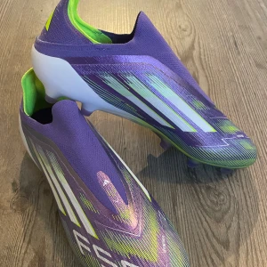 Adidas F50 Elite LL AG fotbollsskor - Säljer ett par Adidas F50 Elite LL AG fotbollsskor i lila med vita och neongröna detaljer. Endast testade. 