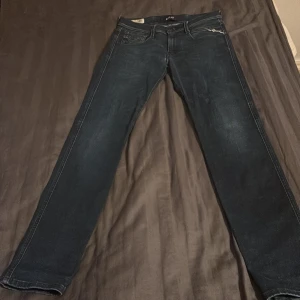 Replay Anbass Hyperflex jeans, mörkblå - Snygga Replay Anbass Hyperflex jeans i mörkblå tvätt med klassisk femficksdesign och slim fit. Stretchigt material för extra komfort och rörelsefrihet. Diskreta Replay-loggor på fickorna och midjan. Perfekt passform för dig som gillar stilrena jeans.