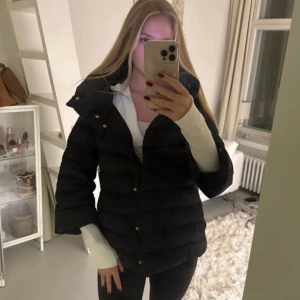 Herno jacka - Säljer en svart herno jacka med hög krage och snygga guldfärgade knappar. Jackan har en loose passform och är perfekt för kalla dagar. Den är långärmad och har ett stilrent, enkelt utseende som funkar till många olika outfits. Storlek är  IT 42/EU 38