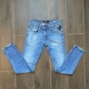 Replay Anbass blå - Snygga blå Replay Anbass jeans med slim fit passform och klassisk femficksdesign. Jeansen har en ljus tvätt med slitningar och detaljerade sömmar på bakfickorna. Tillverkade i stretchig denim för en bekväm känsla och perfekt passform. Om du har frågor eller vill diskutera priset så är det bara att skriva😄