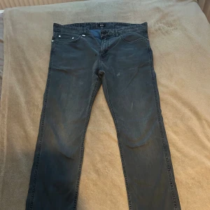 Jeans från BOSS - Snygga blå jeans från BOSS med klassisk femficksdesign och raka ben. Jeansen har en stilren look med diskret BOSS-logga på bakfickan och är tillverkade i mjukt bomullsmaterial med lite stretch för extra komfort. Perfekt för dig som gillar enkel och clean stil.