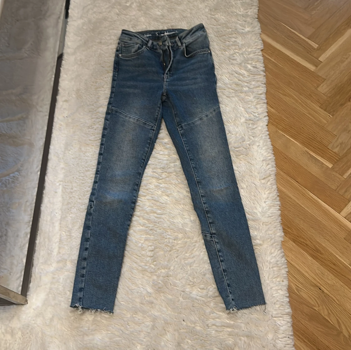 Blå skinny jeans med råa benslut