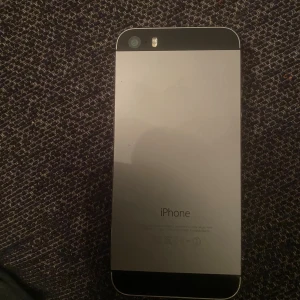 iPhone SE - Apple iPhone SE i klassisk design med aluminium- och glasbaksida. Telefonen visar mindre tecken på slitage och några små repor, men är i gott skick. Perfekt som reservtelefon eller för dig som vill ha en kompakt smartphone.