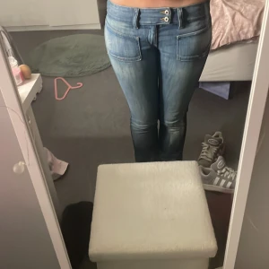 Blå diesel bootcut jeans med detaljer - Snygga blå jeans från diesel med bootcut passform och dubbla knappar i midjan. Låg midja, för dig som gillar 2000 stil. Säljer för dom inte kommer till användning 🫶🏻 kan tänka att sänka pris, skriv om ni vill ha bättre bilder🥰Köpte för mycket mer 