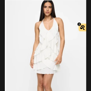 Vit klänning med öppen rygg från Bikbok - Supersöt kort vit klänning med volanger från BikBok. 🤍🤍Klänningen har öppen rygg med knytband. 🤍🤍      Strl: M                                                                                Använd 1 gång.                                                                                    Nypris 499kr säljer för 220kr