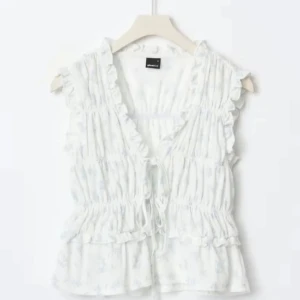 Vit blommig blus med volang och knyt - Supersöt vit blus från Gina tricot med ljusblått blommönster, volangdetaljer och knyt framtill. Ärmlös modell med v-ringning och smockad midja som ger en feminin siluett. Perfekt för dig som gillar romantisk och luftig stil. Endast använd 1 gång! passa på när du får fri frakt🥰