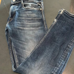 Blå Replay slim fit jeans med slitningar - Feta blå Replay slim fit jeans i W28 L30. Jeansen har en unik tvättad färg, använda men i bra skick bortsett från en liten defekt i byxändan som enbart ser ut som en vanlig slitning och komplementetar designen väl. 