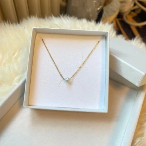 Guldhalsband med pärla - Superfint halsband med tunn guldfärgad kedja och en pärla i mitten. Enkelt och stilrent smycke som passar perfekt till att lyfta vilken outfit som helst. I rostfritt stål!