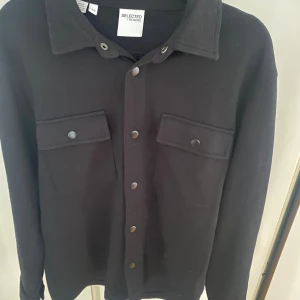 Svart overshirt från Selected Homme - Stilren svart overshirt från Selected Homme. Den är perfekt nu till hösten och vintern. Den passar dig runt 175. Hör gärna av dig vid minsta fundering 🙌🙌
