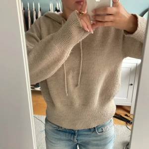 Beige stickad hoodie med huva - Mysig beige stickad hoodie med huva och snörning. Bra skick men lite nopprig. Tröjan är i strl 146-152 men passar mig som oftast har strl S. Kan skicka mått om det önskas.