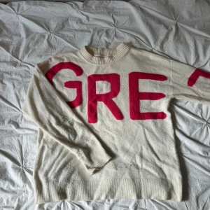 Vit stickad tröja med rosa text YAYA - Vit stickad tröja från YAYA women. Det står ”GREAT” över bröstet och armen. Lite nopprig och en liten fläck på armen men annars fint skick.