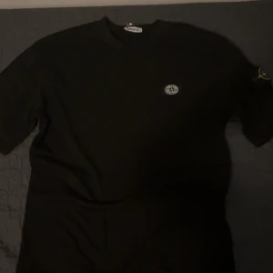 Svart Stone Island t-shirt - Svart stone island t-shirt storlek s men passar också M, t shirten är helt oanvänd inte haft på mig den en ända gång då den inte passa mig så bra men har nu bestämt mig för att sälja (1:1Ko)