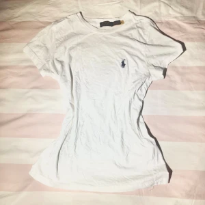 Vit t-shirt från Polo Ralph Lauren XS - Vit t-shirt från Polo Ralph Lauren i bomull med klassisk passform och korta ärmar. Har den ikoniska broderade loggan i mörkblått på bröstet. Perfekt basic-plagg med rund halsringning och mjukt material!💕