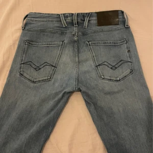 Ljusblå Replay jeans - Snygga ljusblå jeans från Replay med klassisk femficksdesign och raka ben. Jeansen har tydliga sömmar och coola bakfickor med broderad detalj. Perfekta för dig som gillar en avslappnad och stilren look.