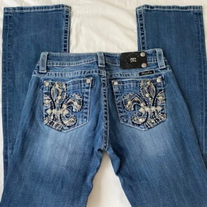 Vintage Miss Me jeans  - Snygga blå jeans från Miss Me med bootcut passform och broderade bakfickor med silverdetaljer. storlek 28 men små i storlek 