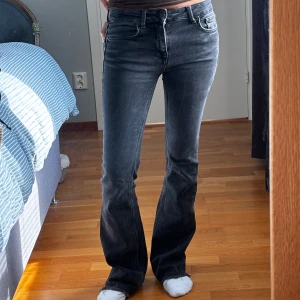 Svarta bootcut jeans med rå kant - Snygga svarta jeans med bootcut-modell och rå, fransad kant nertill. Jeansen har klassisk femficksdesign, normal passform och är tillverkade i jeansmaterial. Medelhög midja. Passar XS 