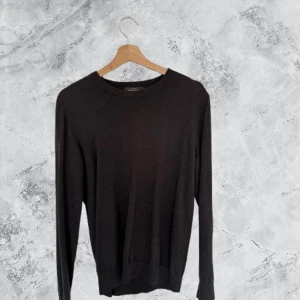 Svart tröja från Dressmann i bomull - Svart långärmad tröja från Dressmann i mjuk Supima bomull. Enkel och stilren design med rund hals och ribbade muddar vid ärmslut och nederkant. Perfekt för dig som gillar klassiska och cleana plagg.