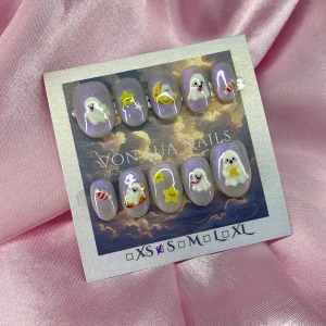 SpookyBoo(S);ExtraShortOval  - Supergulliga handgjorda press-on naglar i lila med glitter, dekorerade med 3D-spöken, gula stjärnor, måne och godisdetaljer. Naglarna har en extra kort oval form och kommer i S: 15 mm, 11,5 mm, 12 mm, 11 mm, 9 mm . Perfekt för dig som vill ha en unik och lekfull look.