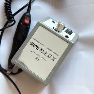 BEAUTYLUSHH MK-0008043 Nagelfil Elfil - Elektrisk nagelfil från BEAUTYLUSHH, modell MK-0008043. Utrustad med justerbar hastighet, strömbrytare och LED-indikator. Synligt bruksslitage och repor på höljet, men i fungerande skick. Perfekt för manikyr och pedikyr hemma.