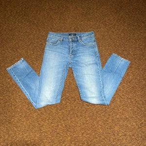 Blå slim jeans från Neuw - Snygga ljusblå jeans från Neuw med klassisk femficksdesign och skinny passform. Jeansen har normal midja, dragkedja och knapp framtill samt slitningar för en cool look. Perfekta för dig som gillar stilrena och moderna jeans.