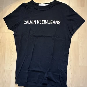 Calvin Klein svart t-shirt - Svart t-shirt med texten "CALVIN KLEIN JEANS" tryckt på framsidan.