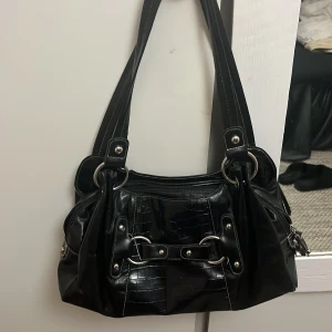 Svart axelväska med silverdetaljer - Vintage snygg väska. Den är typ medel storlek men med massa bra utrymme 