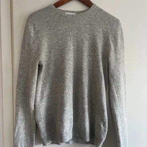 Ljusgrå stickad tröja Topman XS - Säljer en stilren ljusgrå stickad tröja från Topman Premium i storlek XS. GÅR NER I PRIS VID SNABB AFFÄR‼️Tröjan har rund halsringning och är tillverkad i en mjuk mix av ull, nylon, viskos och kashmir. Perfekt för lager-på-lager och passar till allt.