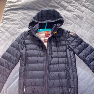 Mörkblå dunjacka Parajumpers S - Fick jackan i present för 1.5 år sen, aldrig använt den. Som ny och fräsh. Inga defekter, missfärgningar, märken eller tecken på användning. Storlek S passar smalare personer sitter snyggt och bredaxlat.  Ny pris exakt samma jacka 5700kr jag säljer betydlig mkt billigare.