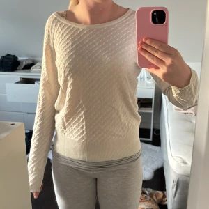 Ljusbeige stickad tröja med knyt från Vila - Supersöt ljusbeige stickad tröja från Vila i storlek S. Tröjan har ett diskret prickigt mönster, ribbade muddar och en snygg öppen rygg med knytband. Perfekt för dig som gillar detaljer och mjuka material. Tyvärr är den lite använd.