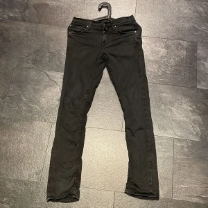 Svarta jeans från Tiger of Sweden/Skinny jeans - Svarta jeans från Tiger of Sweden med klassisk femficksdesign och raka ben. Snygga detaljer med logotyp vid fickan och på insidan av midjan. Jeansen har normal passform och är tillverkade i mjukt bomullsmaterial med lite stretch för extra komfort. 