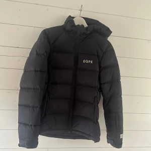 Svart dunjacka från EQPE - Säljer en svart dunjacka från EQPE med huva, använd ett fåtal gånger så i jättefint skick! Storlek XL, men liten i storlek så passar mig som vanligtvis har S/M på jackor💓