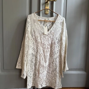 Vit spetsklänning från Spell - Spetsklänning från Spell med v-ringning och vida ärmar. Klänningen kan användas med eller utan underklänning. Säljs med separat underklänning. Bägge plaggen är oanvända. ( nypris 3200 ) 