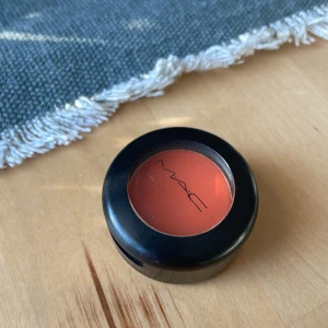 MAC Orange Matte Ögonskugga - Snygg orange matt ögonskugga från MAC i färgen Orange. Kommer i en rund svart plastförpackning med genomskinligt lock och MAC-logga. Perfekt för dig som vill ha en färgstark look och älskar att experimentera med färg på ögonlocken. Använd enstaka gång och självklart rengjord 