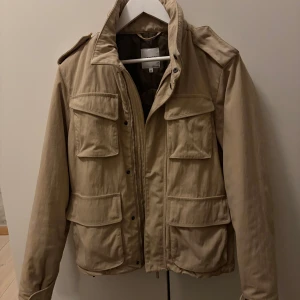Field jacka från aspesi - Säljer min snygga och beigea field jacka ifrån Aspesi. Storlek M och superbra skick!