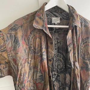 Vintage mönstrad skjorta  - Unik vintage skjorta från RAST med abstrakt mönster i brunt, grått, rött och beige. Skrynklig för att den legat nerpackad. Använt men bra skick - inga defekter. 
