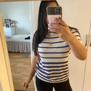Vit och lila randig stickad tröja - Säljer en vit och lila randig stickad tröja med korta ärmar och rund hals. Tröjan är från ett okänt märke då den är köpt utomlands, jag köpte den dock för 250kr 🌸