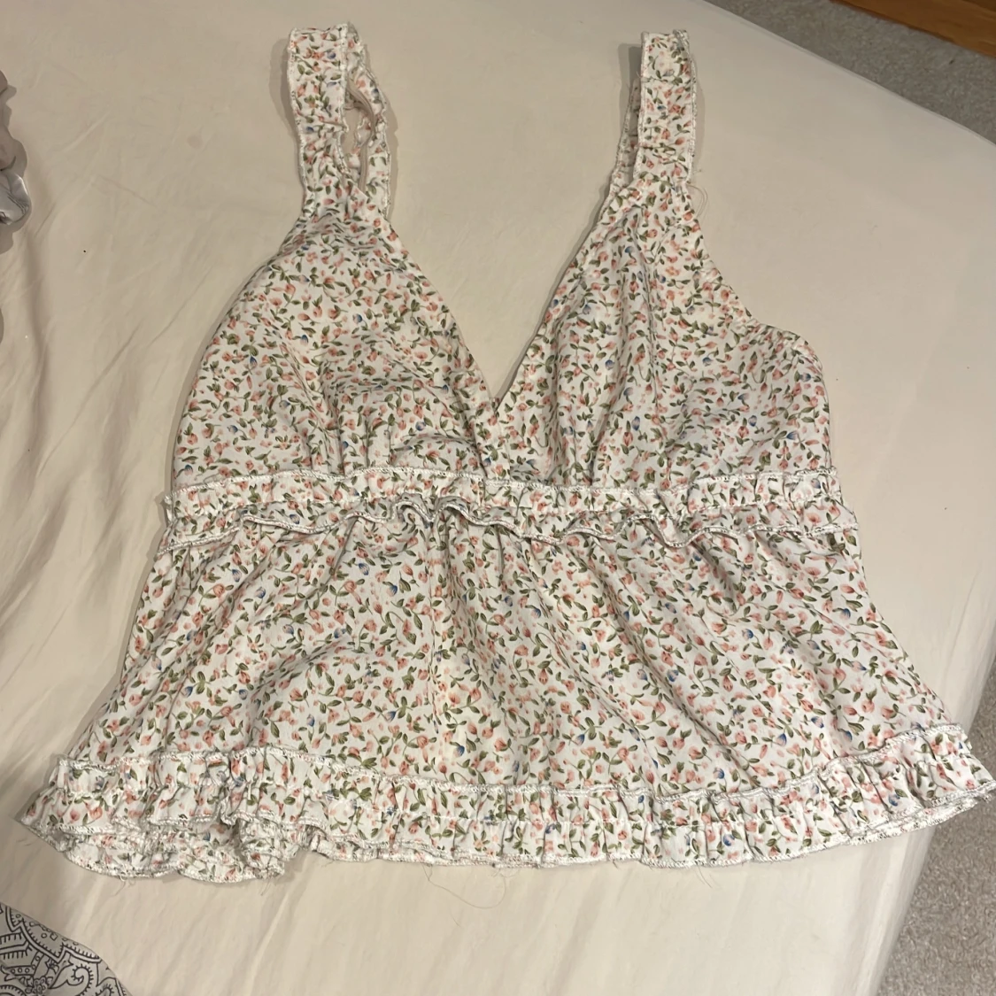 Blommig vit linnetopp med volang