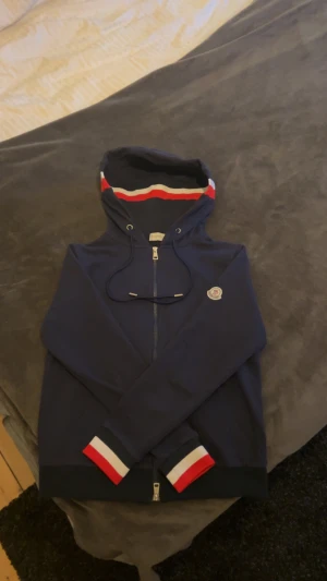 Moncler zip hoodie - Säljer denna Moncler hoodien då den inte passade mig använt den 2-3 gånger ser helt ny ut. Riktig bra kvalite och en riktig snygg hoodie till dig som vill ha en stillig tröja. Pris kan diskuteras vid snabb affär.