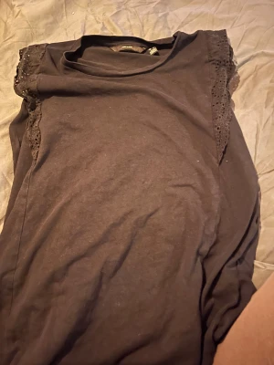 Volang topp - Säljer en svart topp från Vero Moda med volang på axlarna. Är använd men är fortfarande i bra skick. Storlek M😊säljer då den inte kommer till användning längre. 