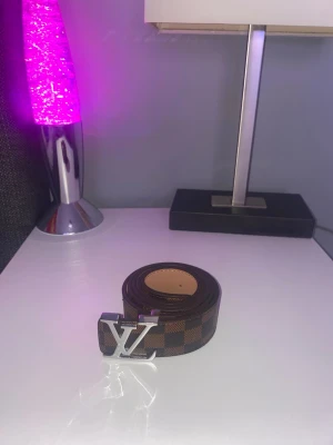 Lv bälte  - Helt nytt med bruna mönster och en silver logga 
