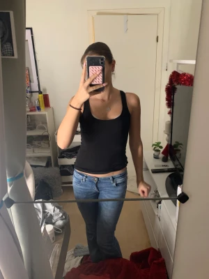 Svart linnetopp❣️ - Säljer en enkel och stilren svart linnetopp med breda axelband och rundad halsringning. Toppen sitter tight mot kroppen, perfekt att matcha med jeans eller kjol. Materialet känns mjukt och stretchigt, vilket gör den bekväm att bära hela dagen. Skriv vid frågor!💘