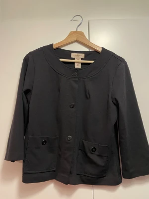 svart kofta med knappar - svart kofta i stretchigt material med stora knappar och trekvartsärmar! second hand, men inte använd av mig.